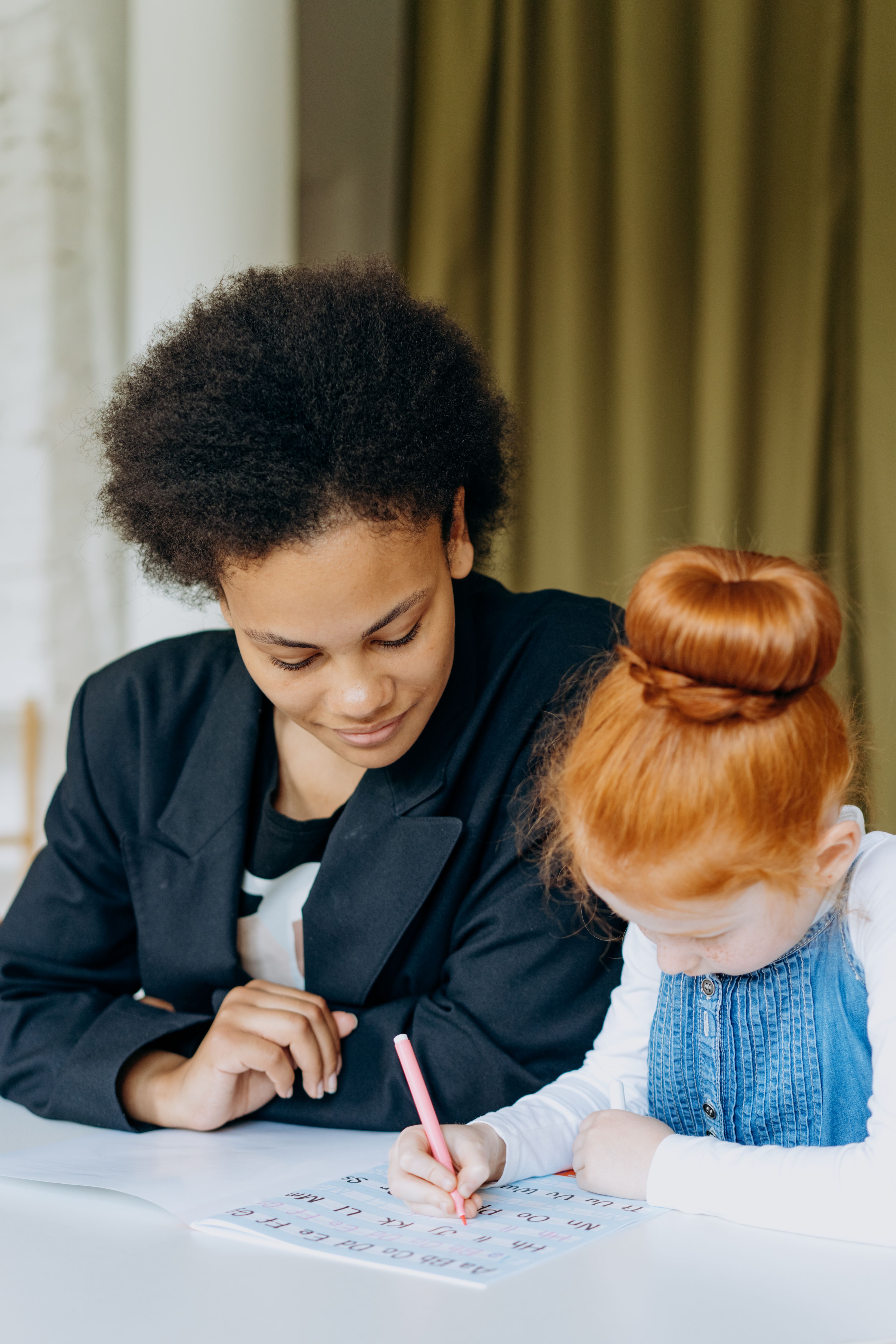 Intervenant(e) Casa Fides aidant une petite fille à faire ses devoirs